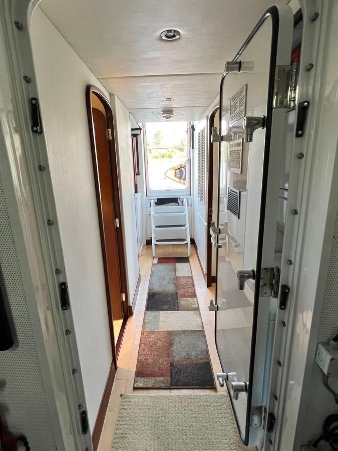 a hallway with doors aboard 2001 BROWARD RAISED PILOTHOUSE MY Yacht for Sale