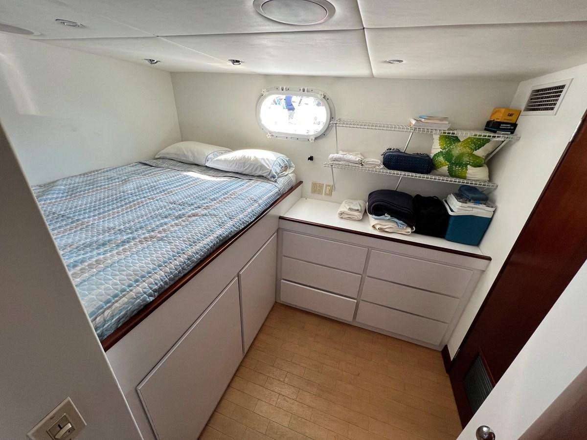 a small room with a bed and a desk aboard 2001 BROWARD RAISED PILOTHOUSE MY Yacht for Sale