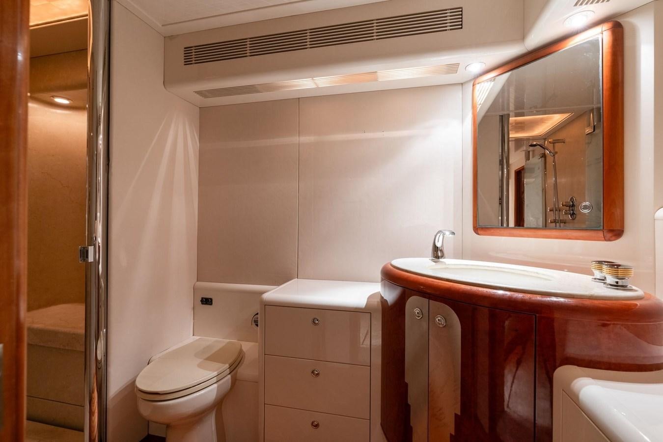 a bathroom with a sink toilet and a mirror aboard 1996 ADMIRAL MARINE 71 Yacht for Sale