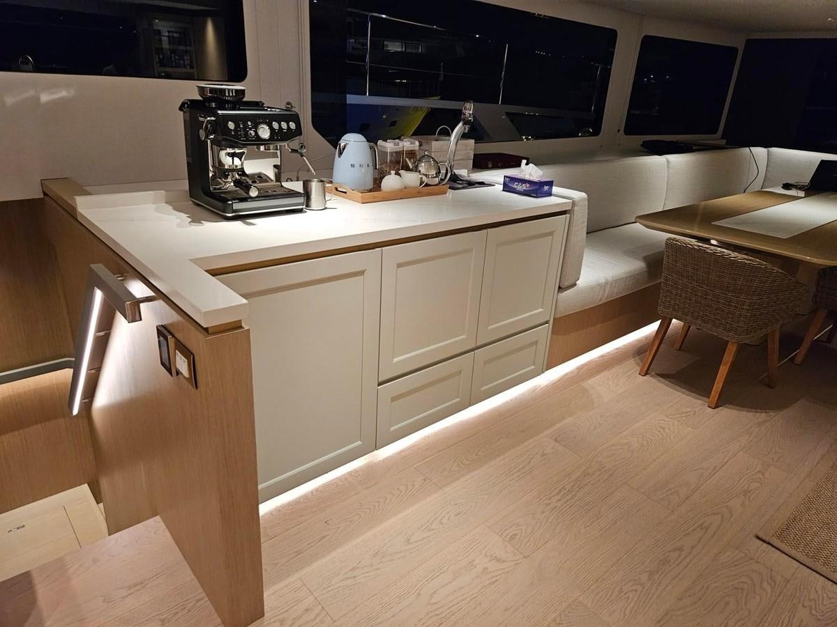 a kitchen with a table and chairs aboard BUNDALONG Yacht for Sale