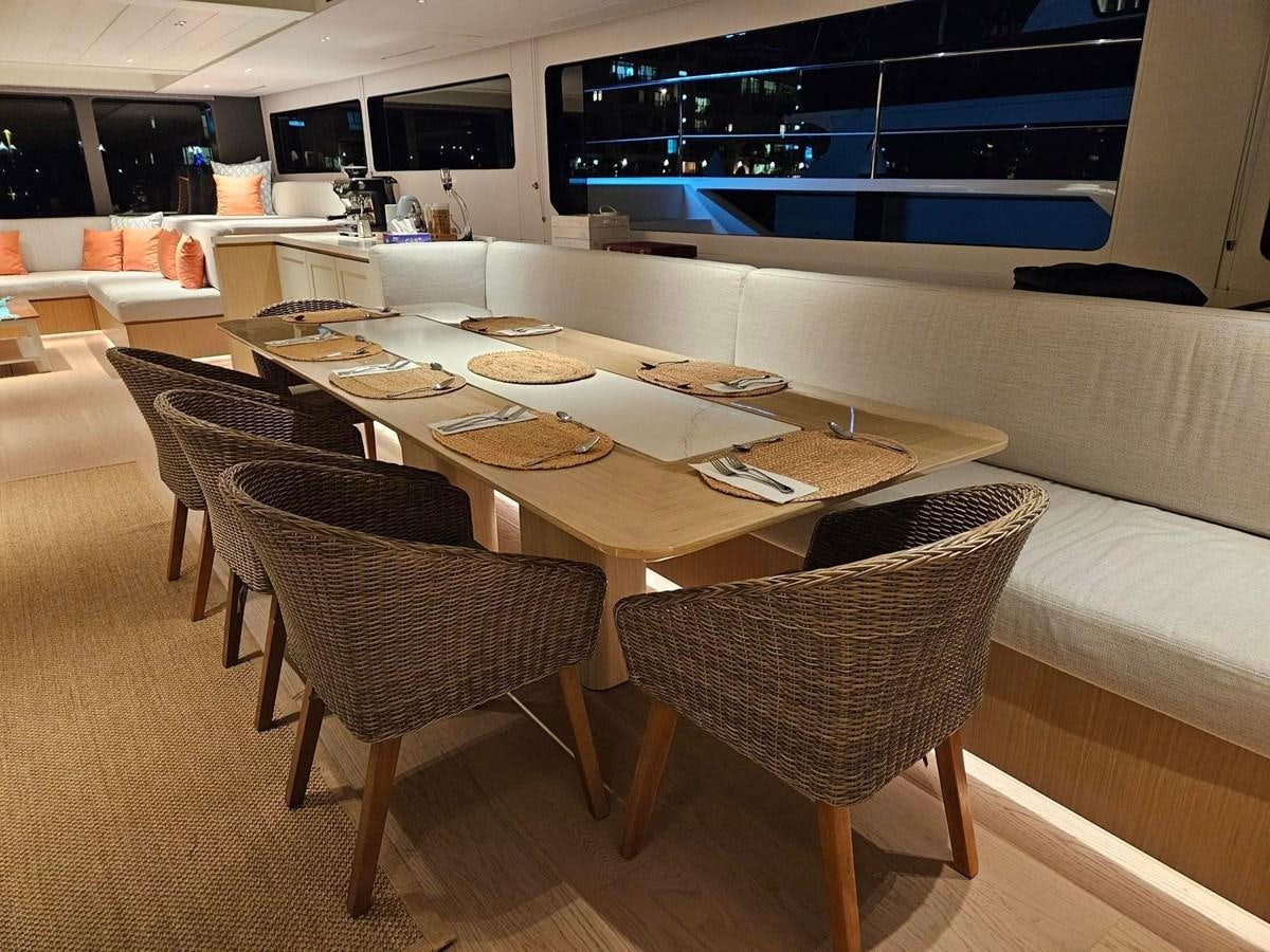 a table with plates and chairs aboard BUNDALONG Yacht for Sale