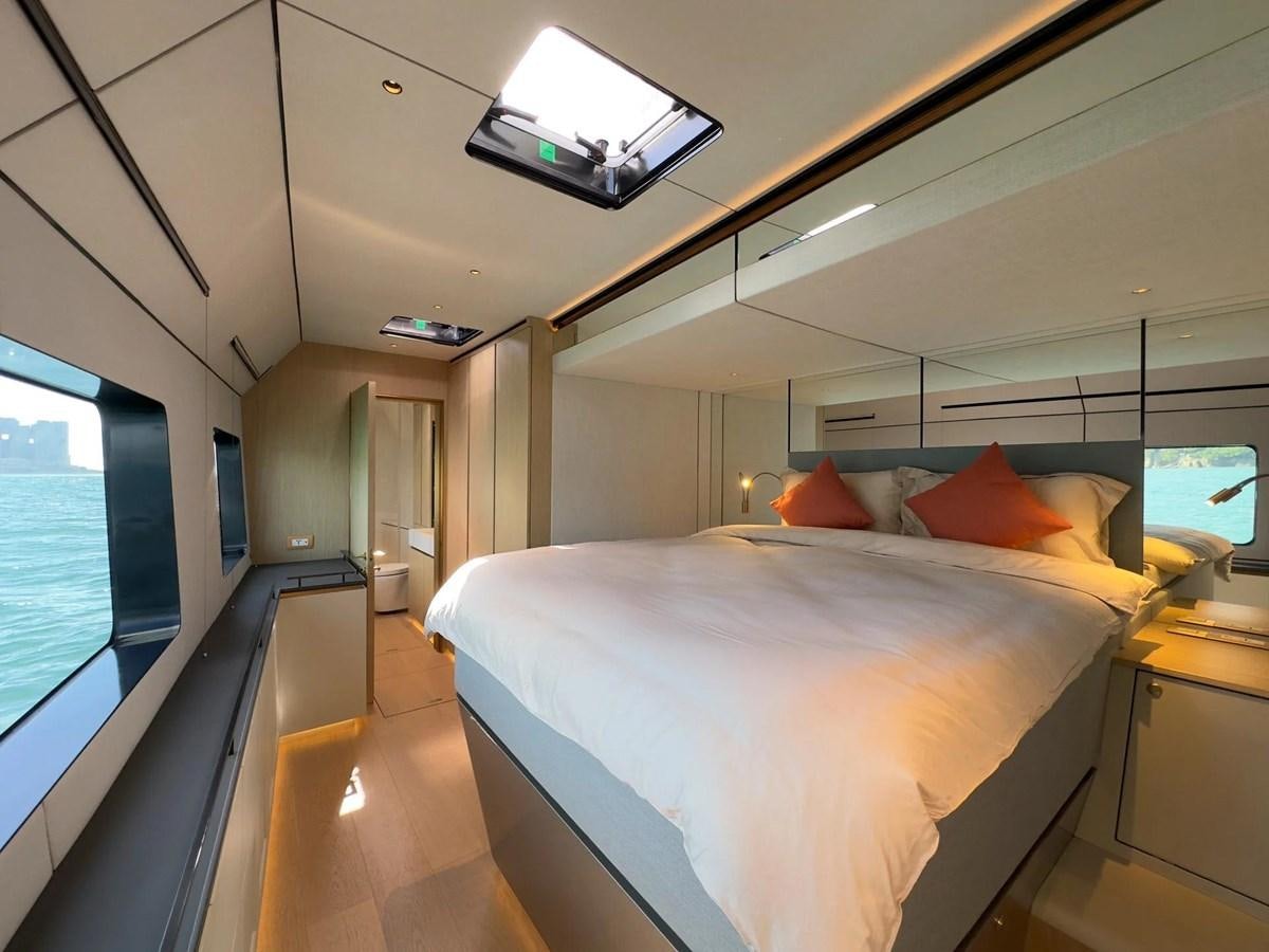 a room with a bed and a tv on the wall aboard BUNDALONG Yacht for Sale