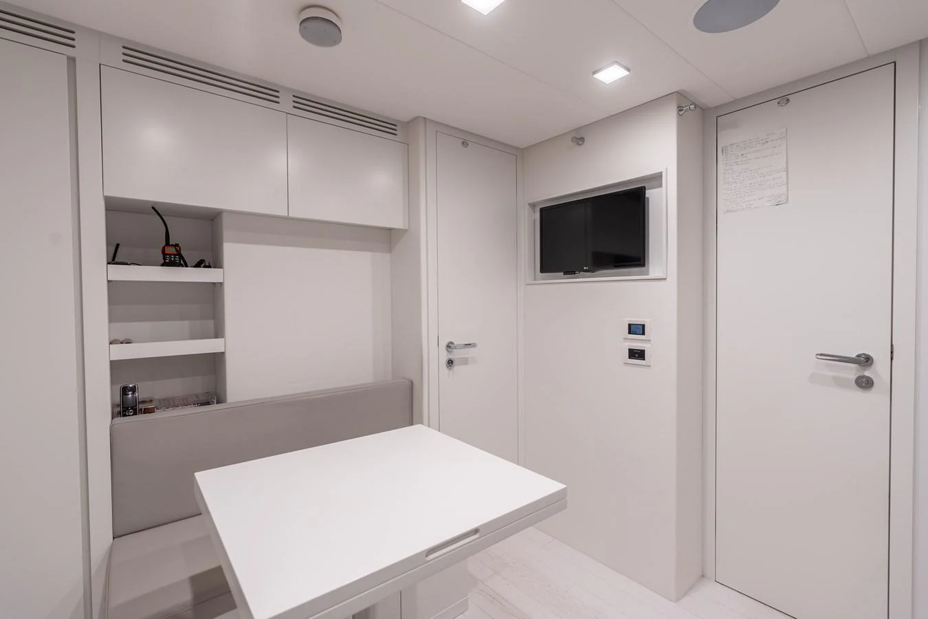 a room with a table and a tv aboard VINTAGE Yacht for Sale
