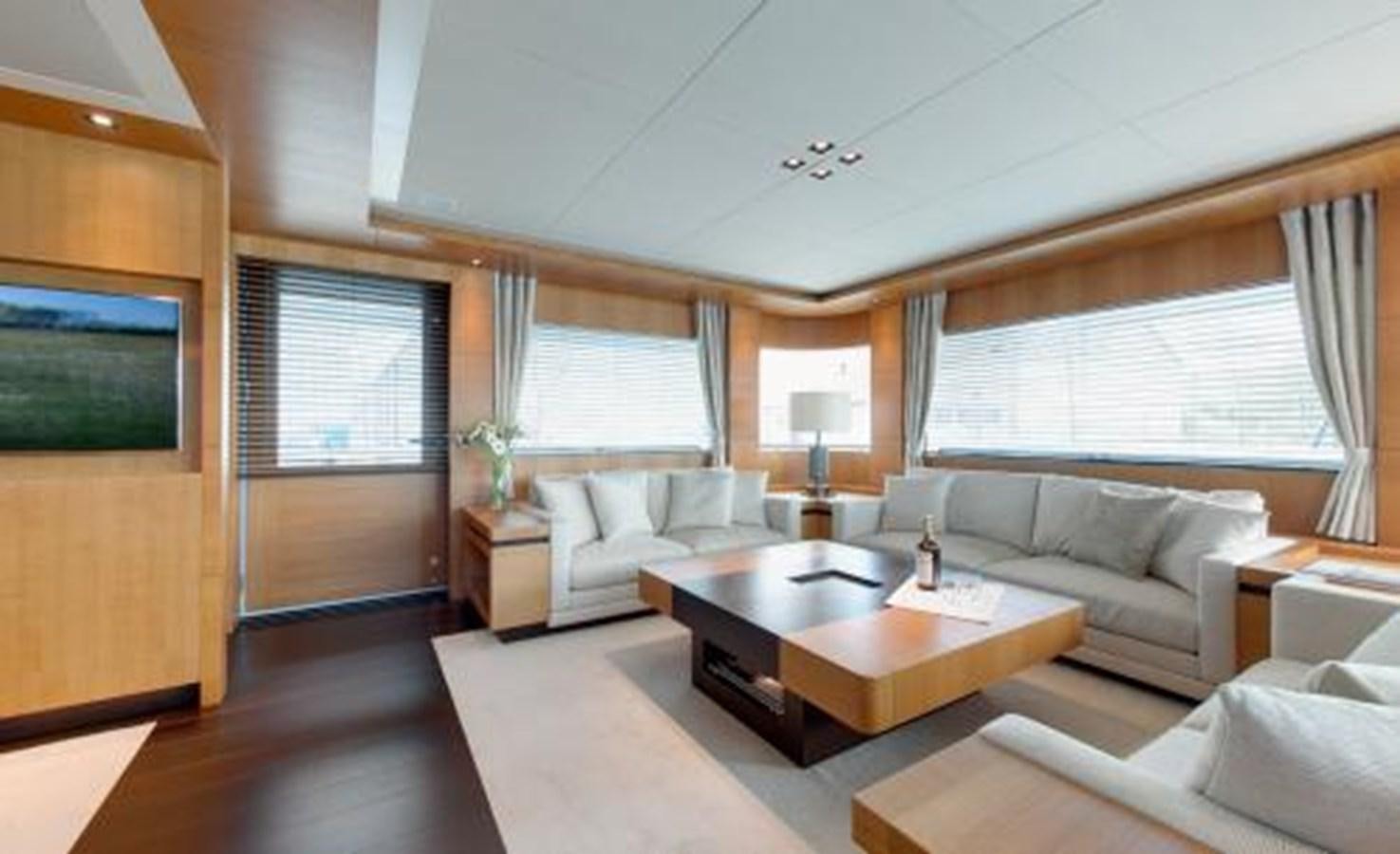 a living room with a table and couches aboard BDJ Yacht for Sale