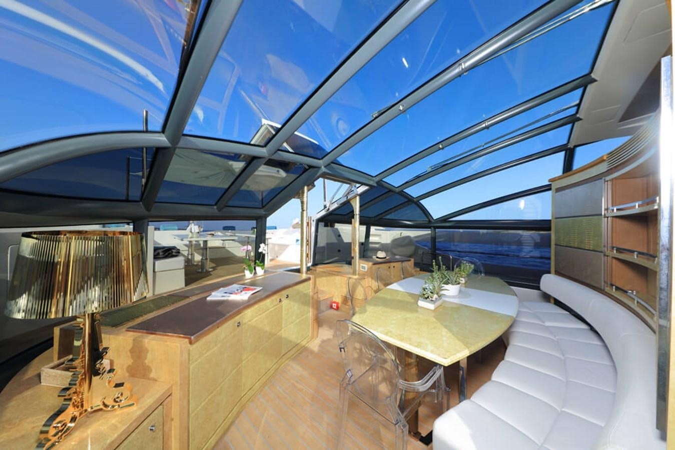 a room with a table and a view of the water aboard BAIA 100 Yacht for Sale