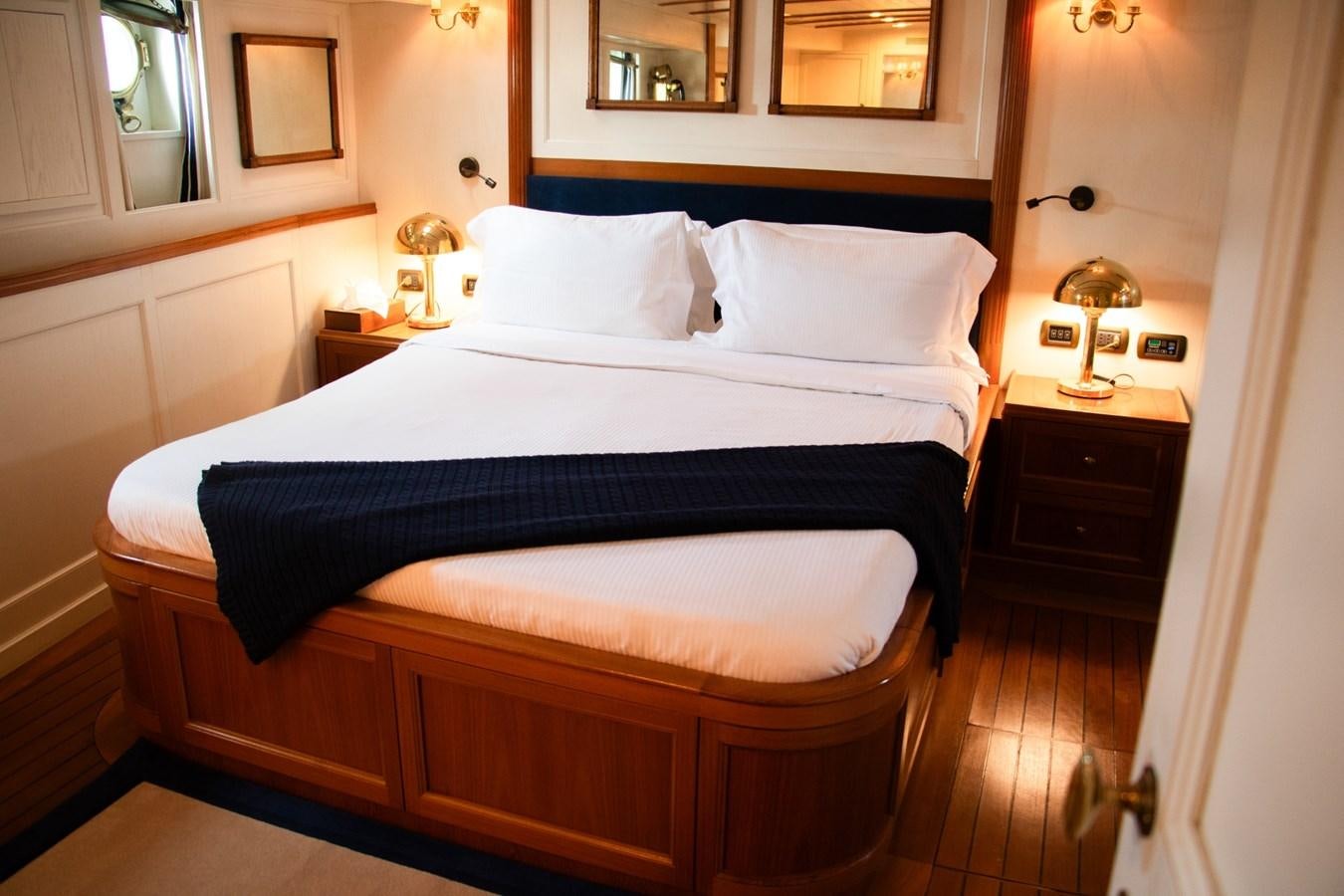 a bed with a blue sheet aboard LADY HERTHA Yacht for Sale