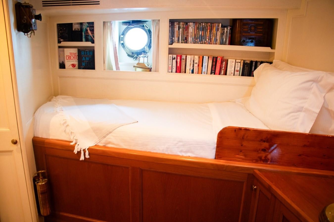 a bed with a mirror above it aboard LADY HERTHA Yacht for Sale