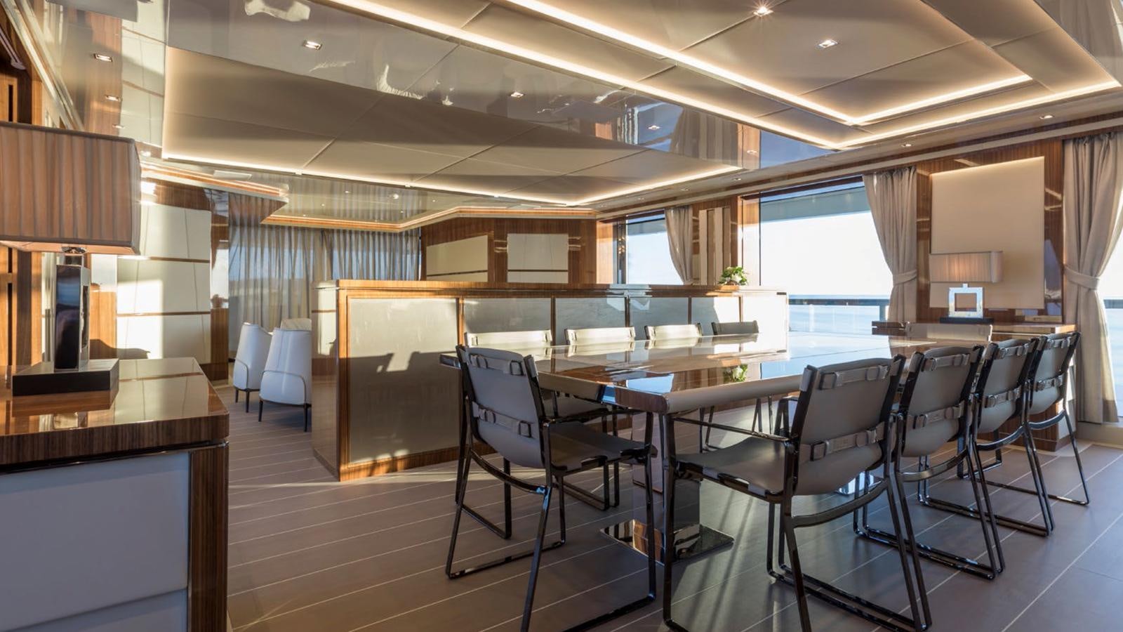 a room with tables and chairs aboard GOLDENEYE Yacht for Sale