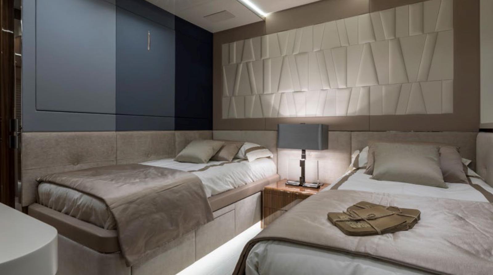 a room with beds and a lamp aboard GOLDENEYE Yacht for Sale