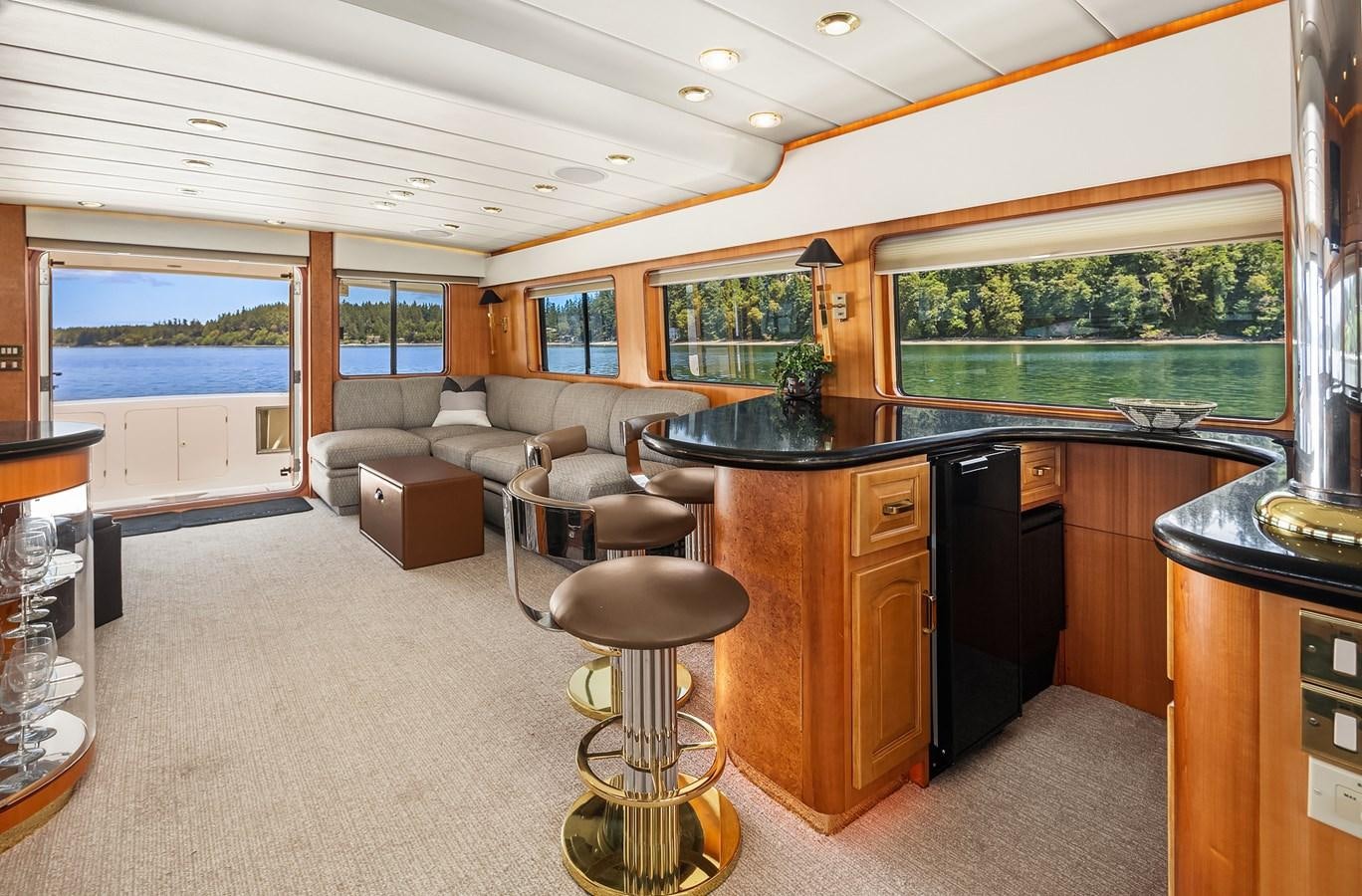 a large living room with a bar and a large window aboard QUE SA-RAH SA-RAH Yacht for Sale