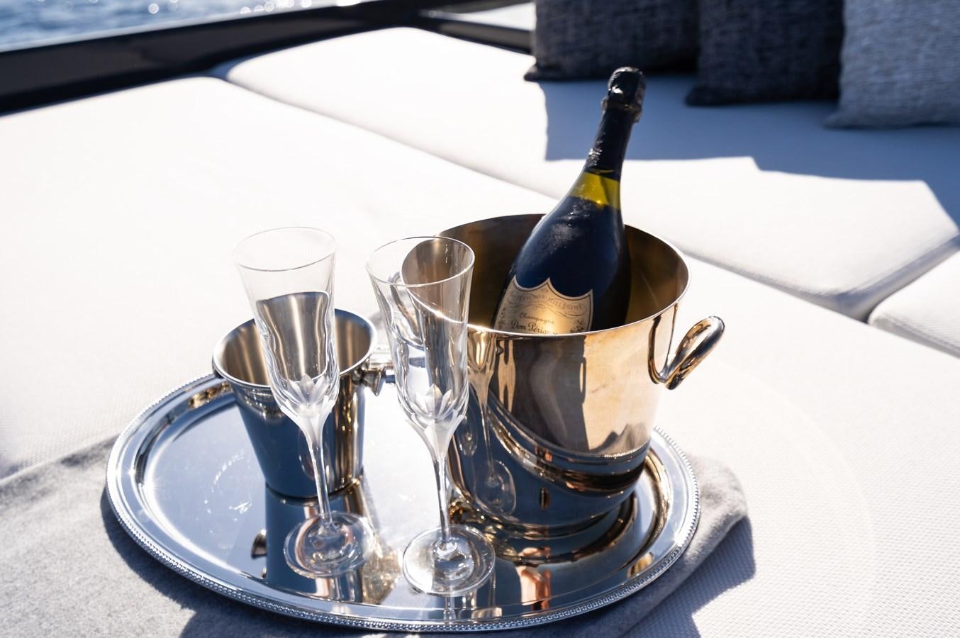 a glass of champagne and a bottle on a table aboard ANMAX Yacht for Sale