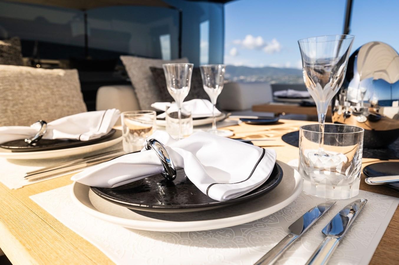 a table with plates and glasses aboard ANMAX Yacht for Sale