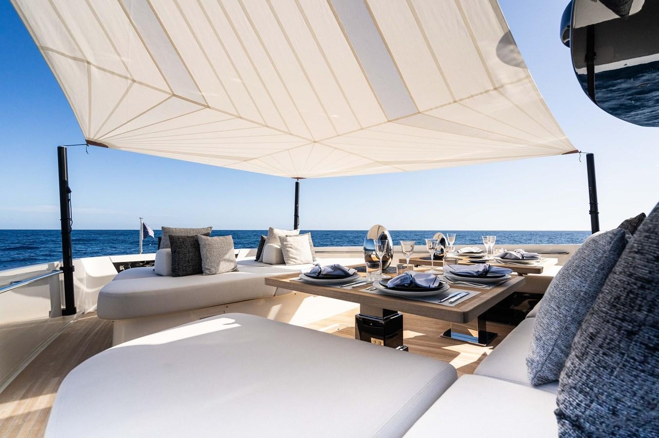 a large white lounge chair next to a large white umbrella on a boat aboard ANMAX Yacht for Sale