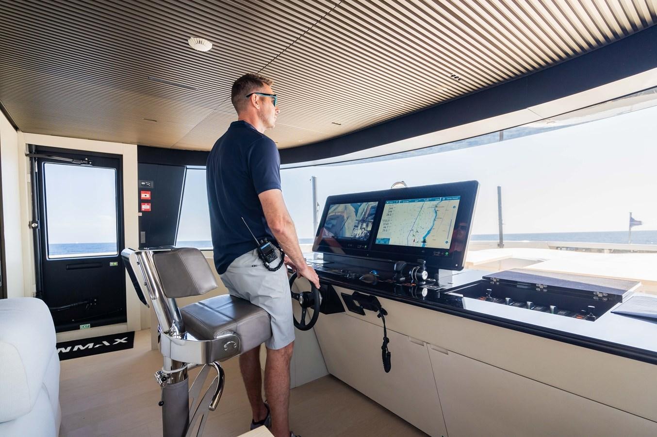 a person standing in front of a large window with a computer on it aboard ANMAX Yacht for Sale