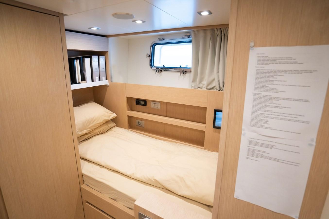 a room with a bed and a bookcase aboard ANMAX Yacht for Sale