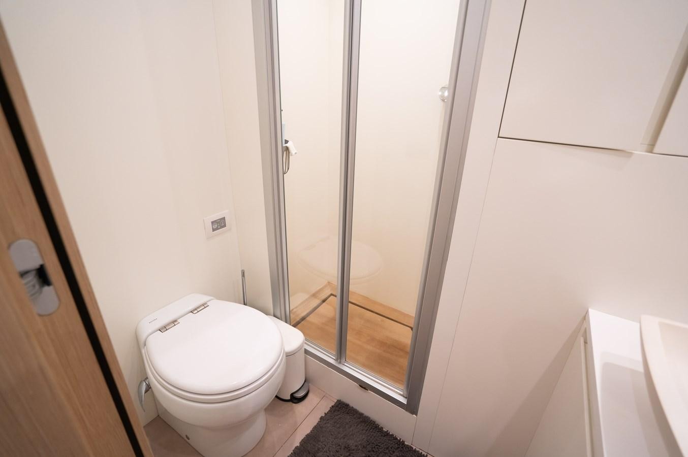 a bathroom with a glass shower door aboard ANMAX Yacht for Sale
