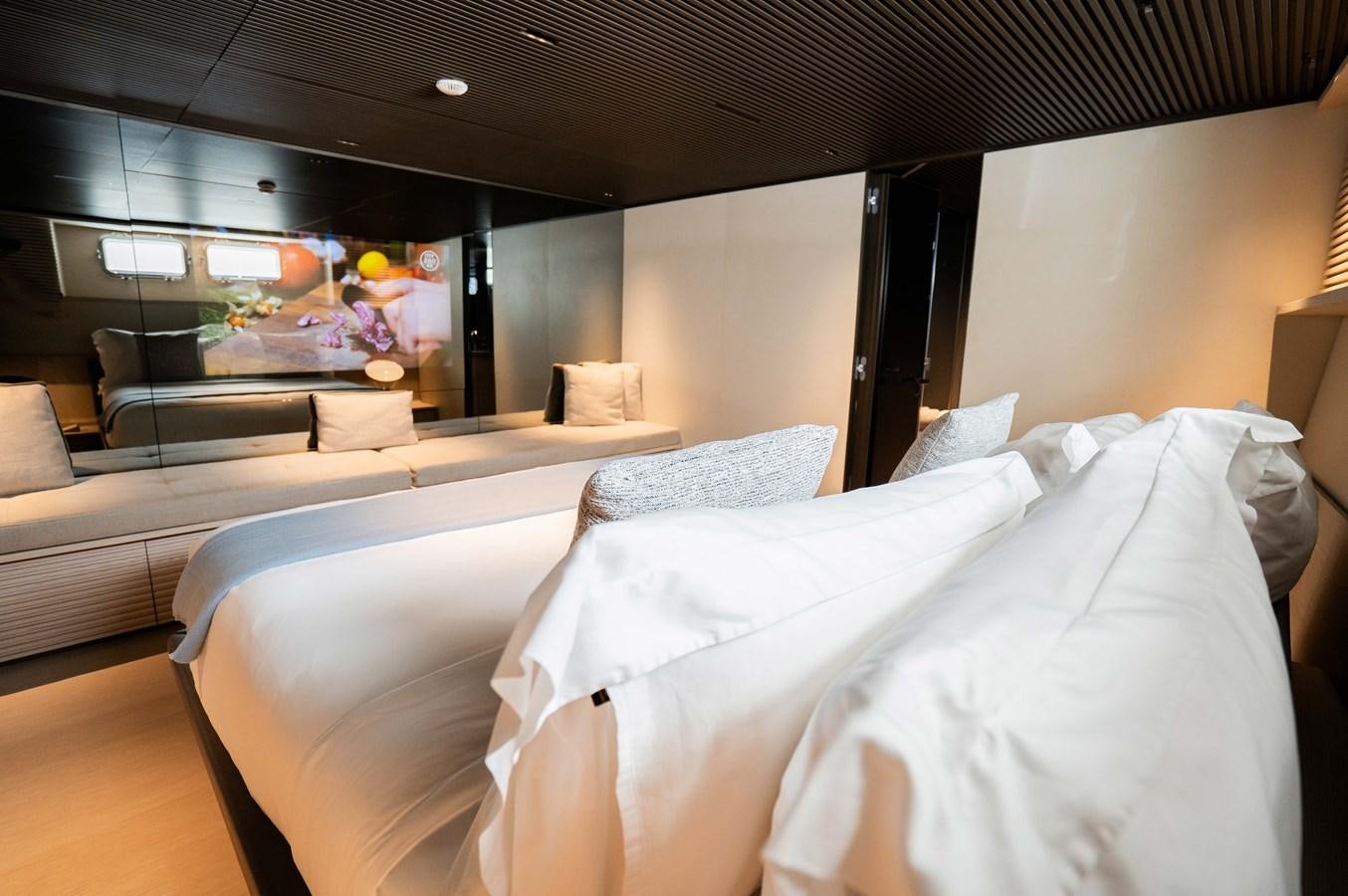 a room with beds and a couch aboard ANMAX Yacht for Sale