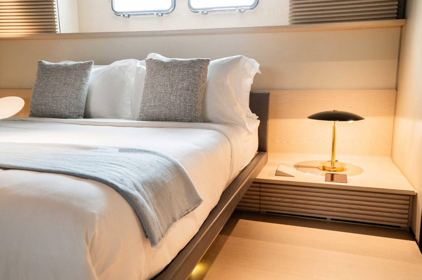 a bed with a lamp on it aboard ANMAX Yacht for Sale