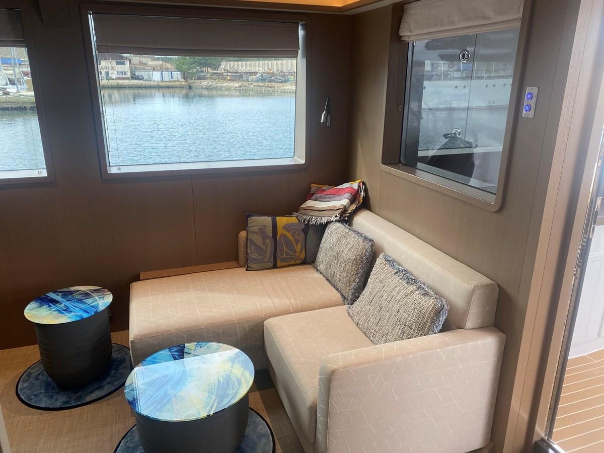 a living room with a couch and a window aboard NO DESTINATION Yacht for Sale