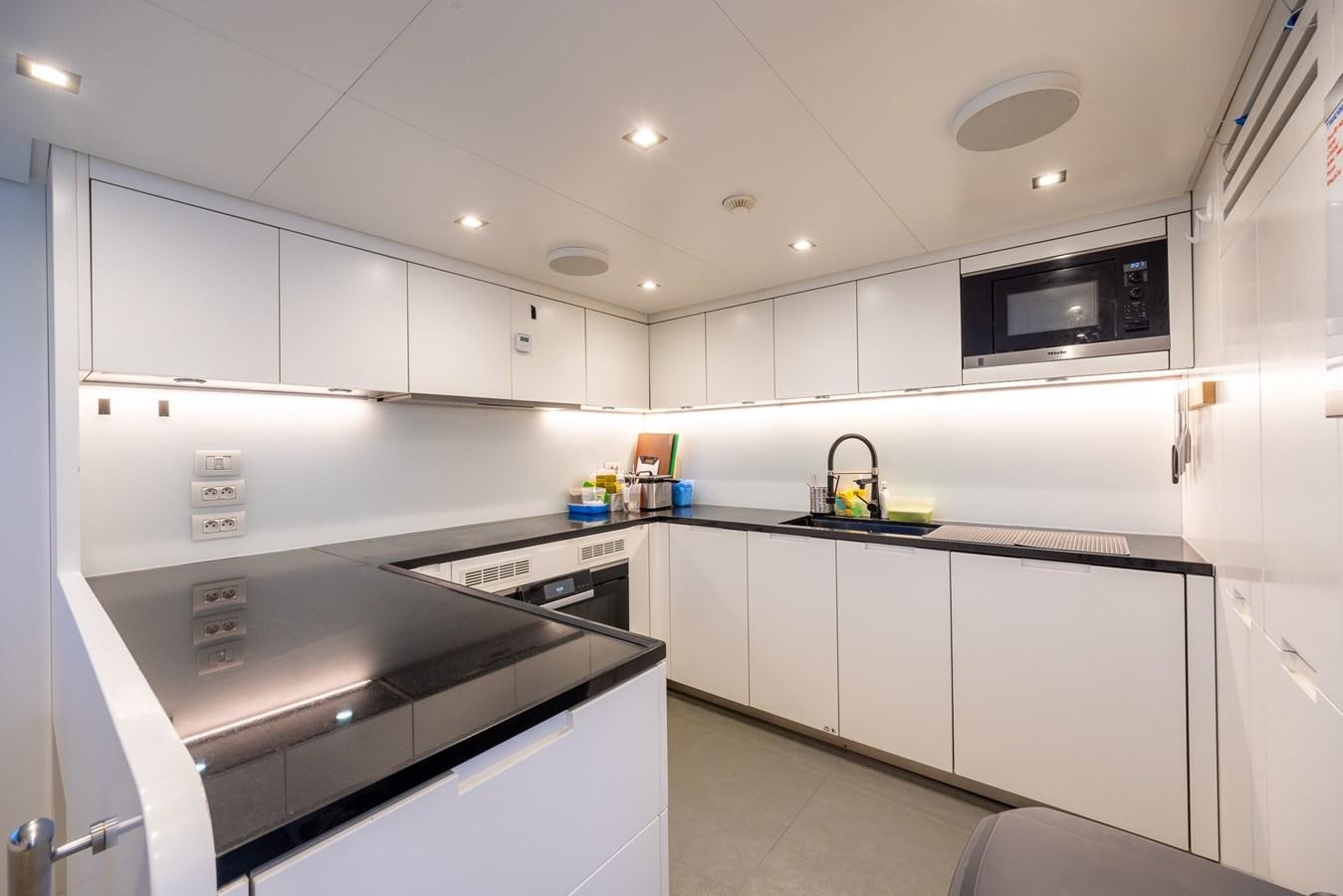 a kitchen with white cabinets aboard ZULU 3 Yacht for Sale