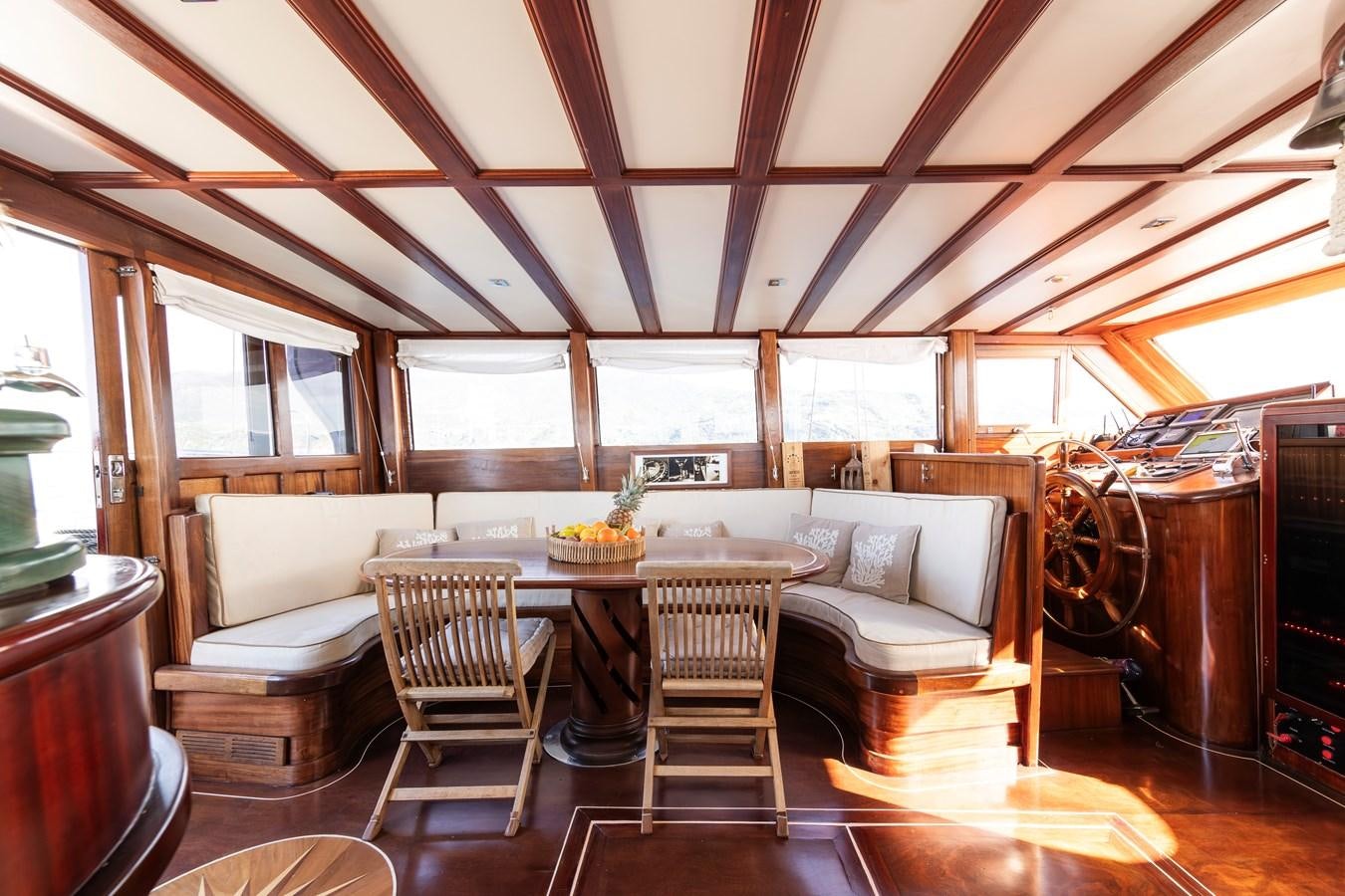 a room with a table and chairs aboard DAI Yacht for Sale