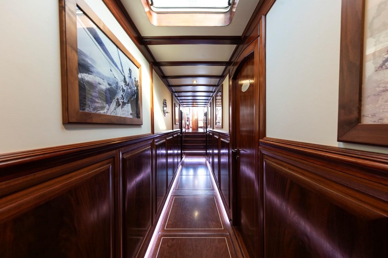 a long hallway with wooden cabinets aboard DAI Yacht for Sale