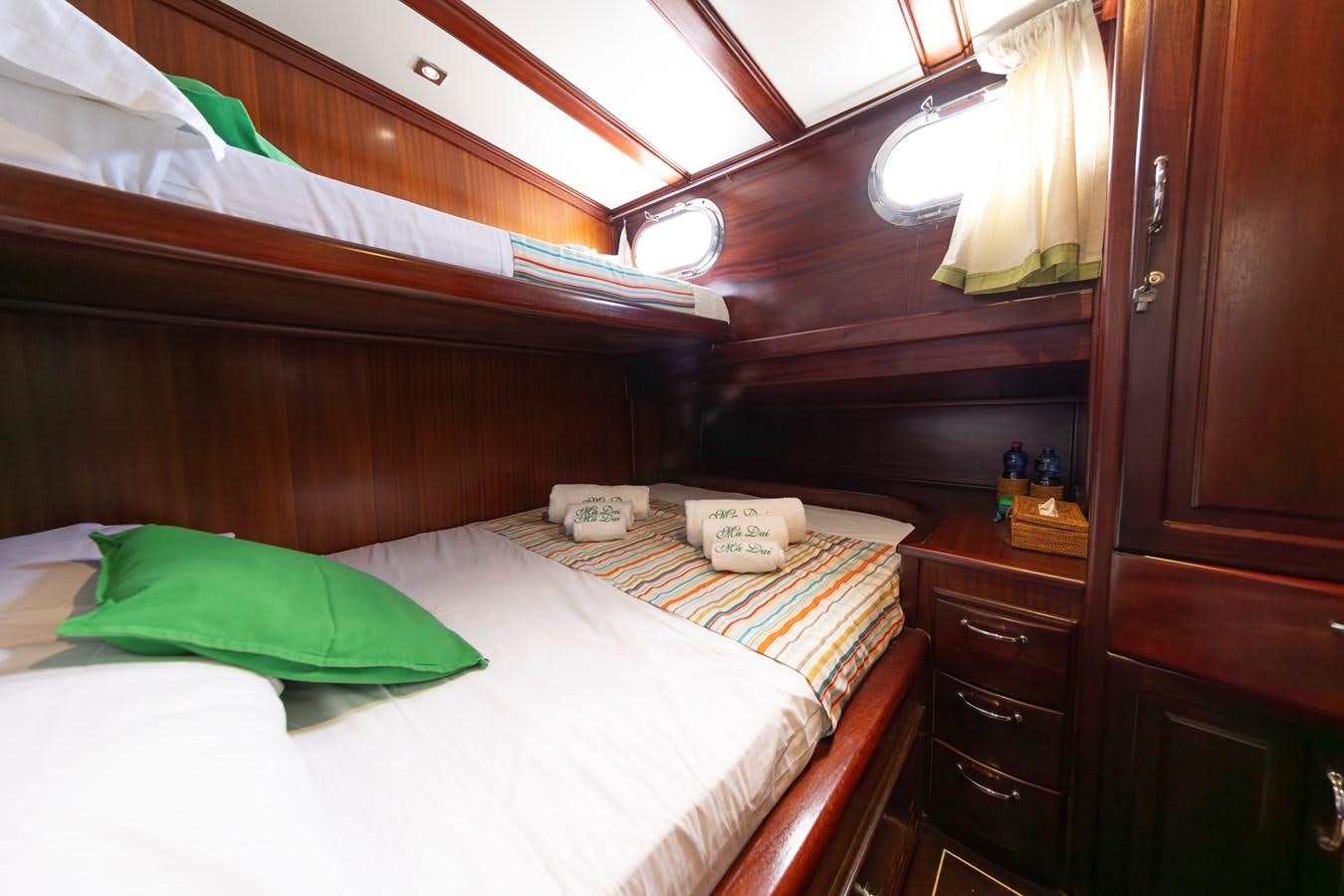 a room with a bed and a dresser aboard DAI Yacht for Sale