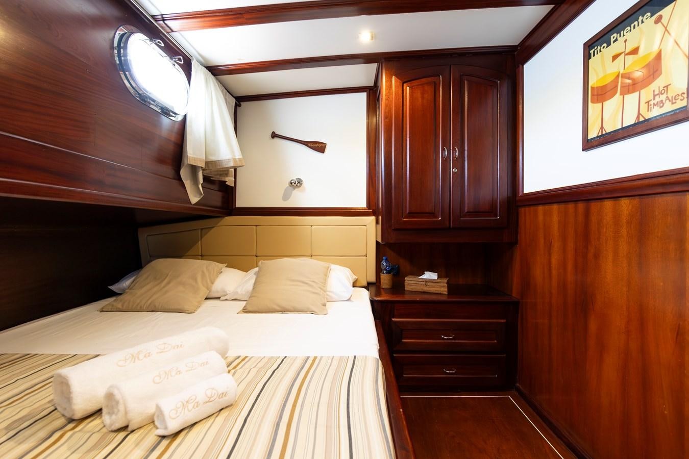 a room with a bed and cabinets aboard DAI Yacht for Sale