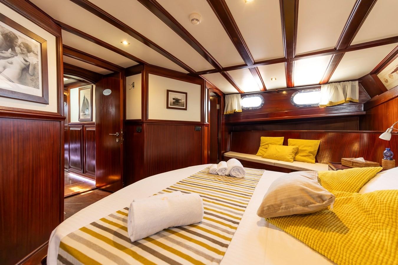 a room with a bed and a mirror aboard DAI Yacht for Sale