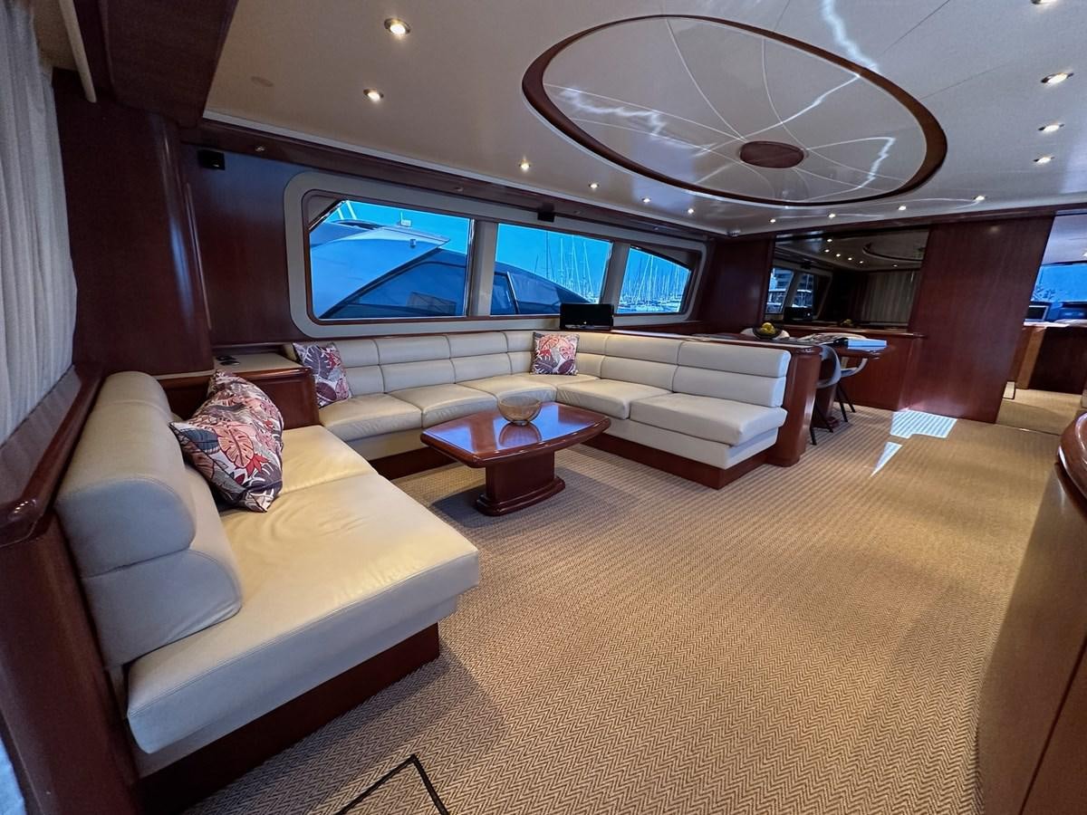 a living room with a large chandelier aboard VIDA LOCA Yacht for Sale
