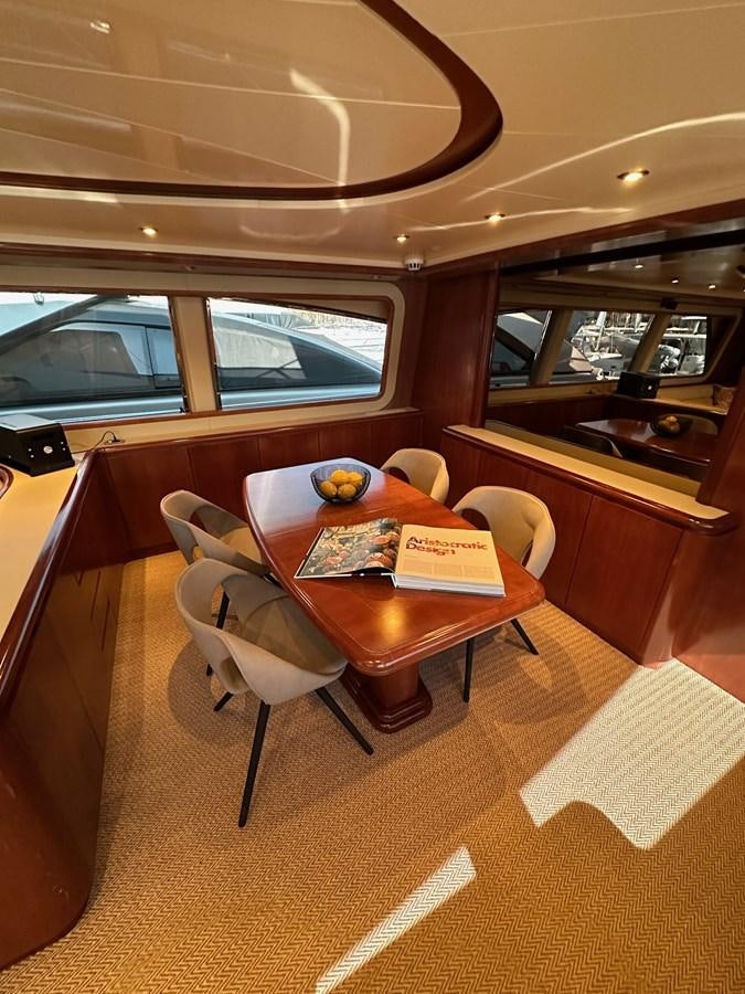 a table with chairs and a window aboard VIDA LOCA Yacht for Sale