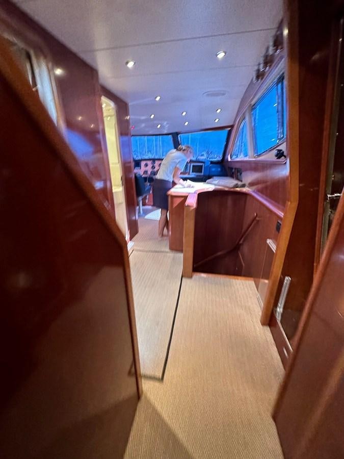 a view of a hallway with a few people and a desk aboard VIDA LOCA Yacht for Sale