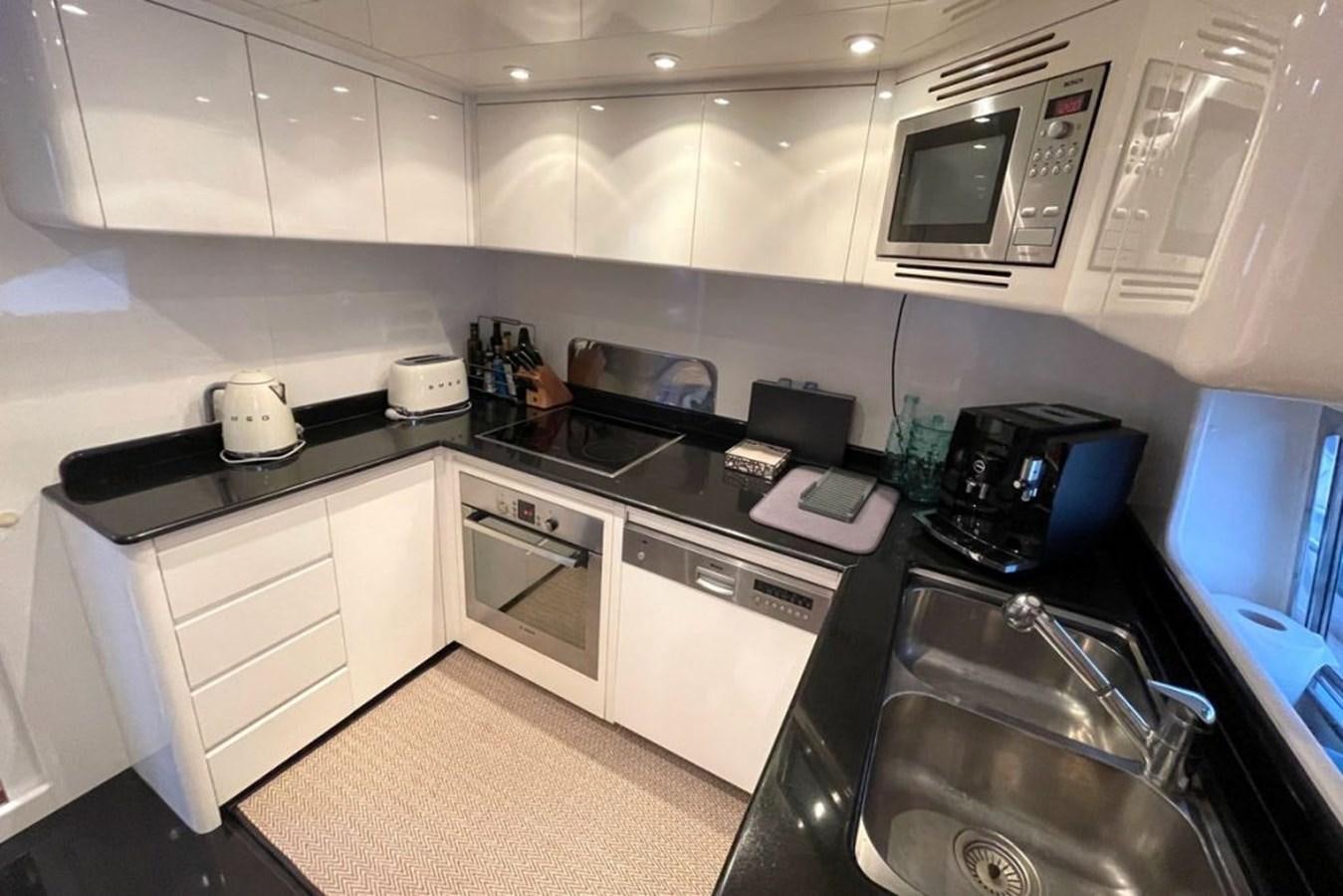 a kitchen with white cabinets aboard VIDA LOCA Yacht for Sale