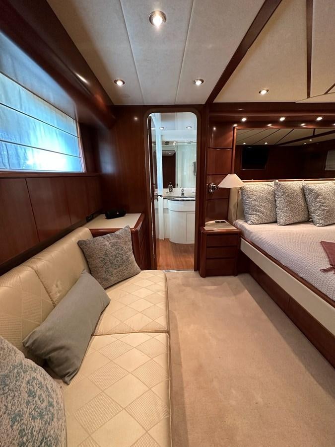 a bedroom with a bed and a mirror aboard VIDA LOCA Yacht for Sale