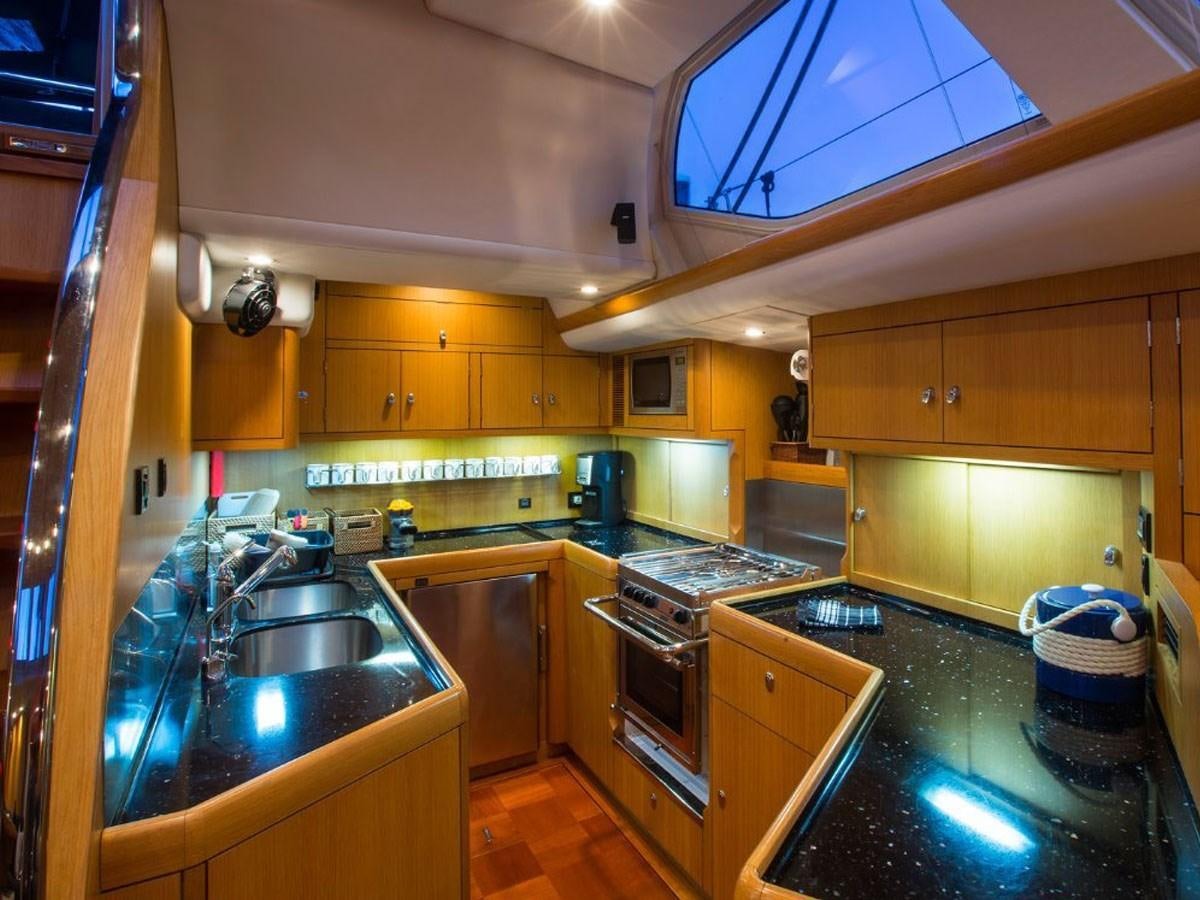 a kitchen with wooden cabinets aboard MATAWAI Yacht for Sale