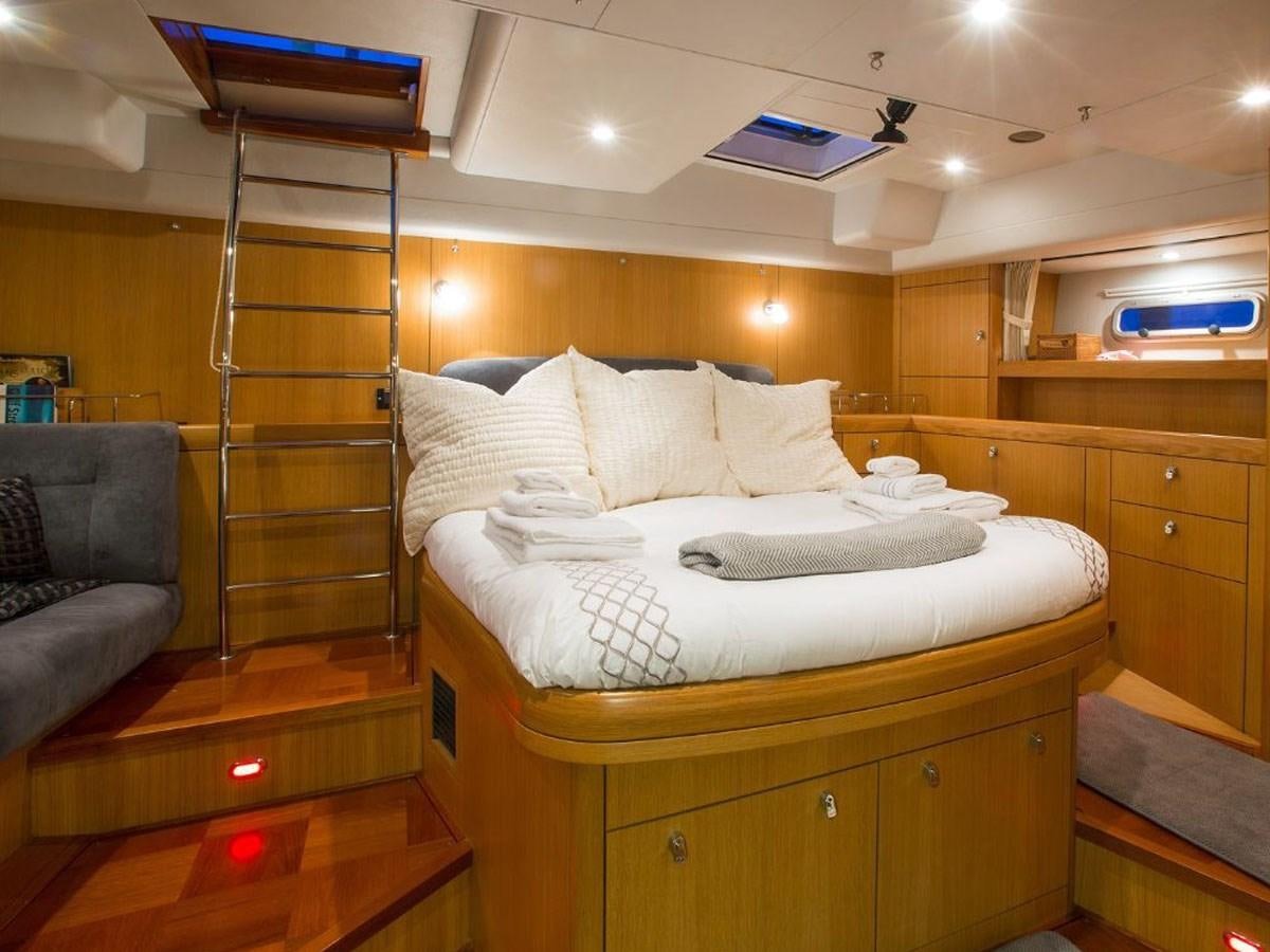 a bedroom with a bed and a chair aboard MATAWAI Yacht for Sale