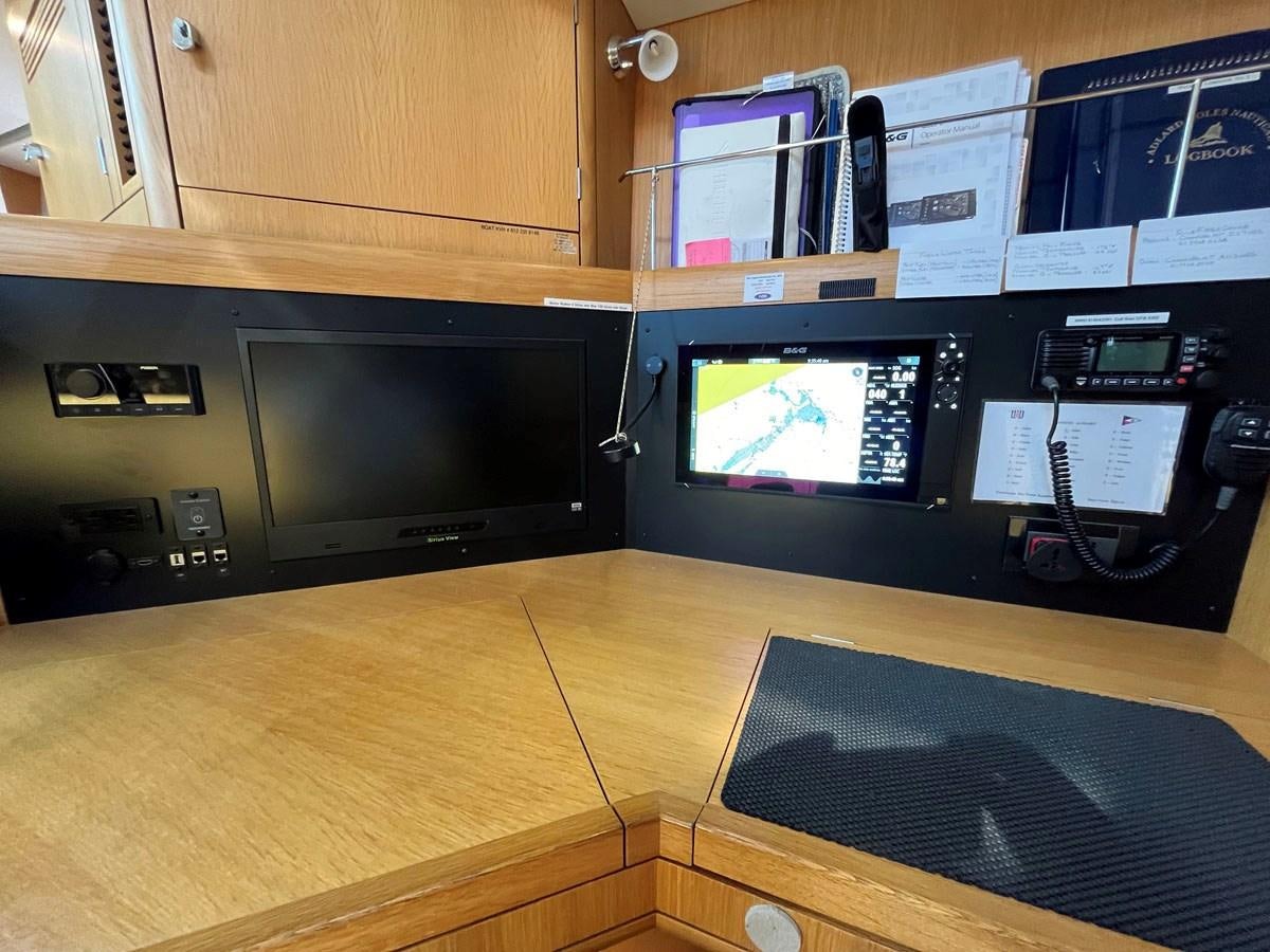 a desk with a computer and a phone on it aboard MATAWAI Yacht for Sale