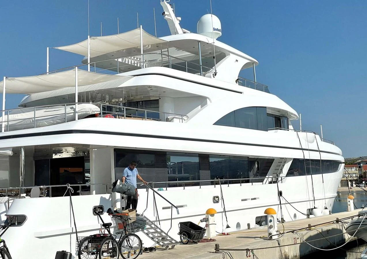 a person standing next to a boat aboard DOMENIKA Yacht for Sale
