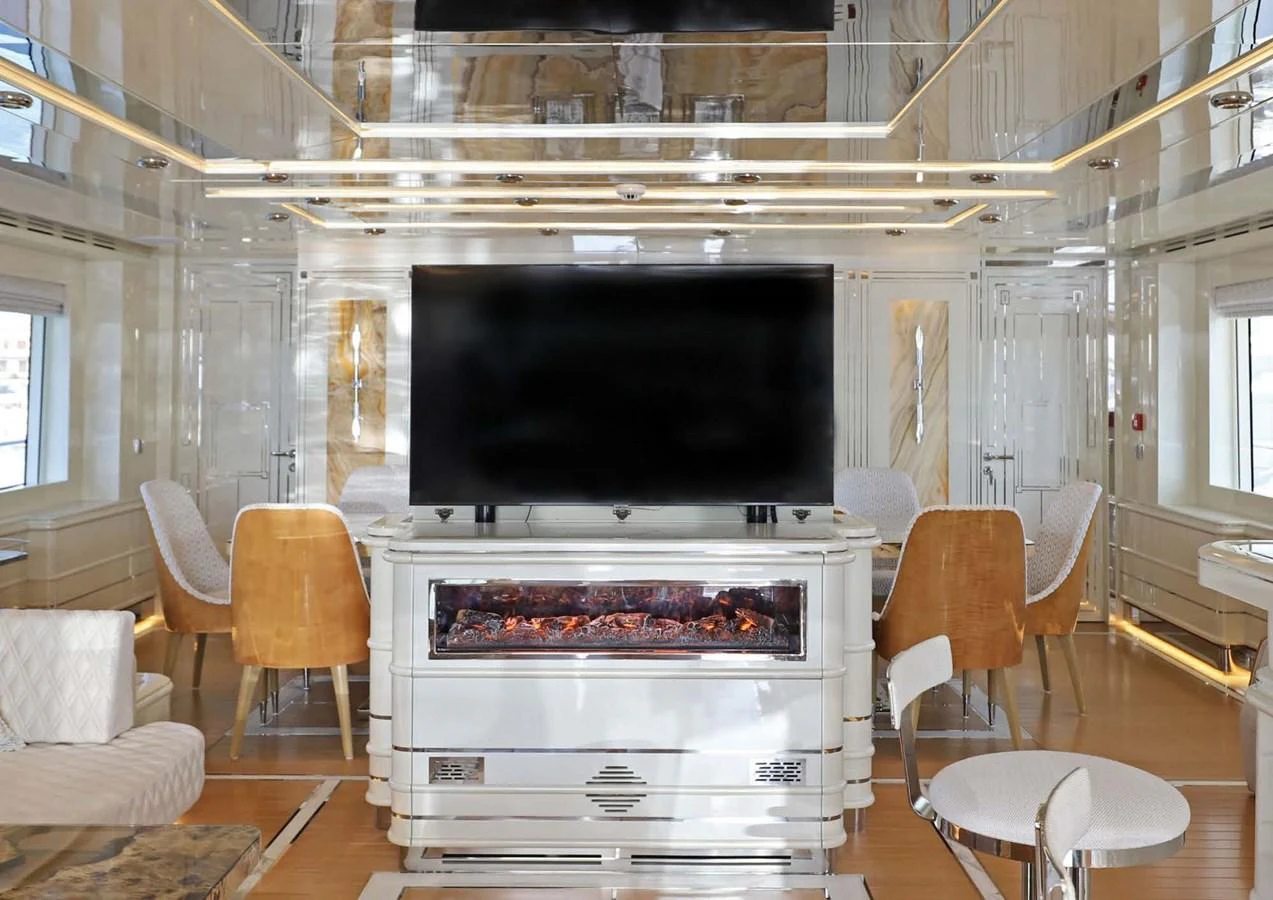 a room with a fireplace and chairs aboard DOMENIKA Yacht for Sale