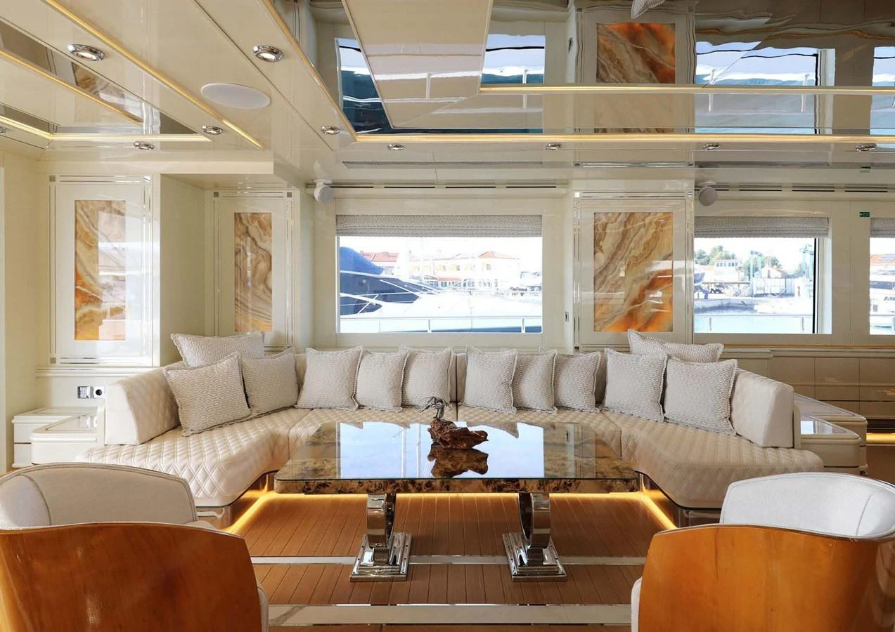 a room with a couch and a table with chairs aboard DOMENIKA Yacht for Sale