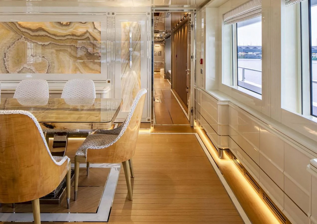 a room with a table chairs and a window aboard DOMENIKA Yacht for Sale