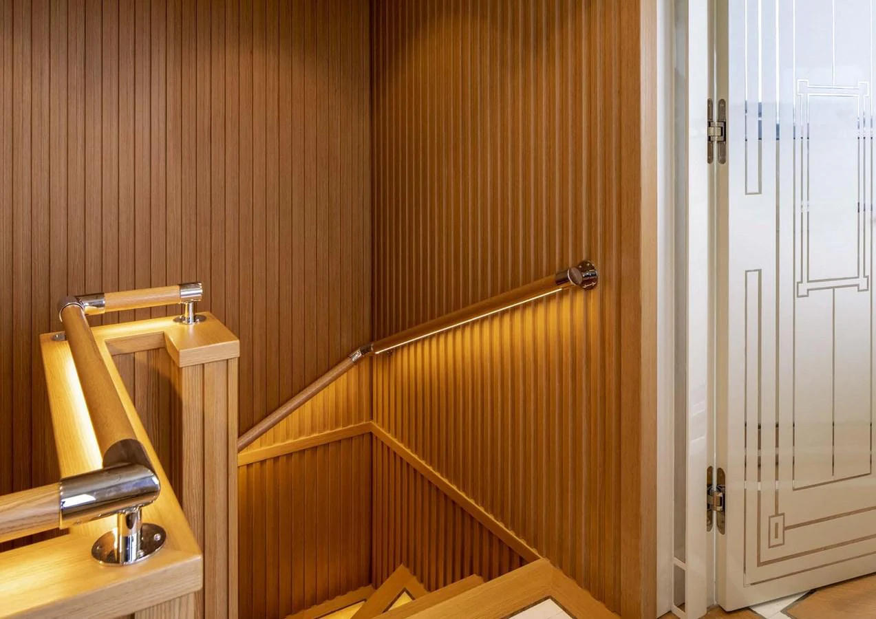 a wooden staircase with a white door aboard DOMENIKA Yacht for Sale
