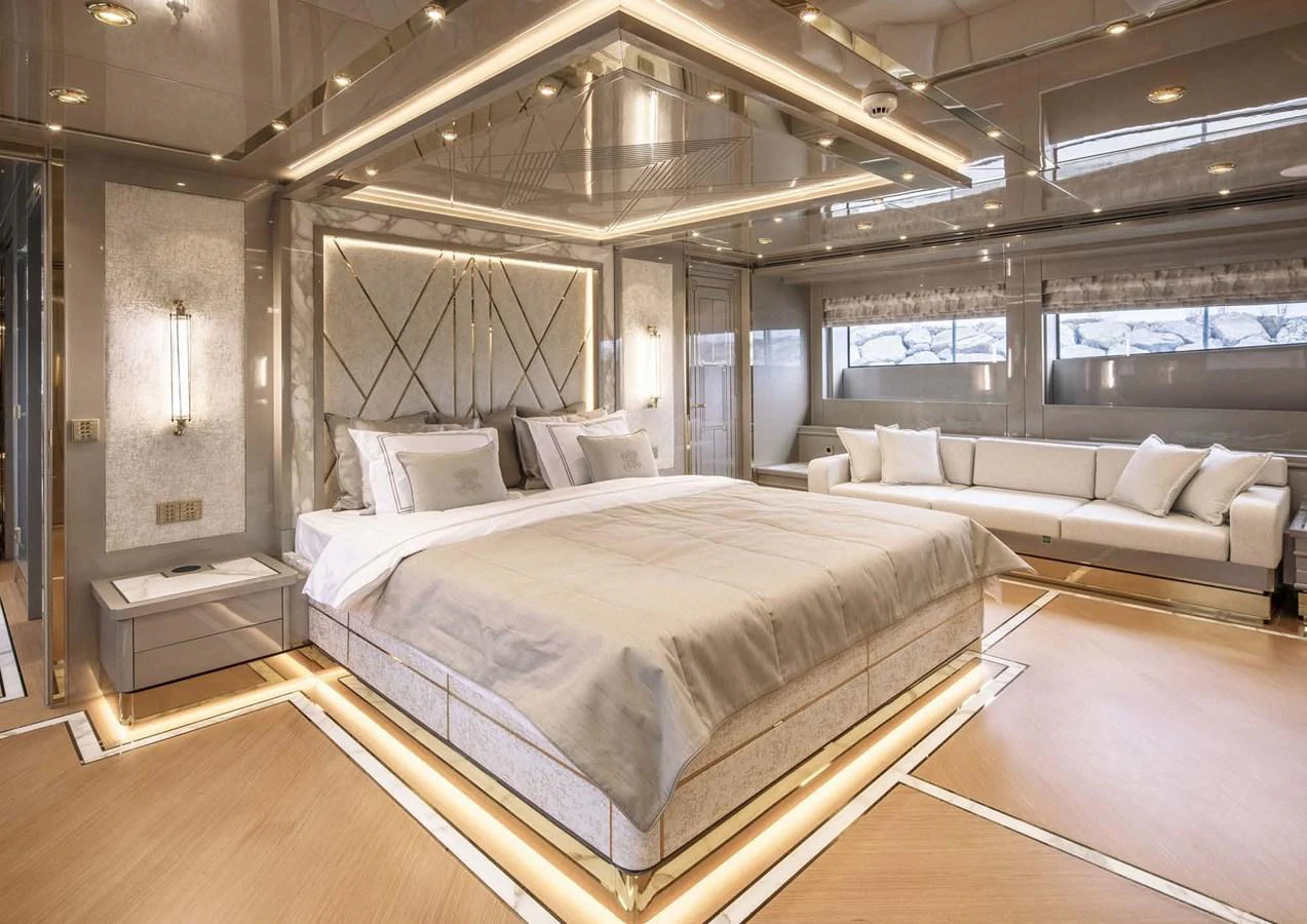 a large room with a bed and a couch aboard DOMENIKA Yacht for Sale