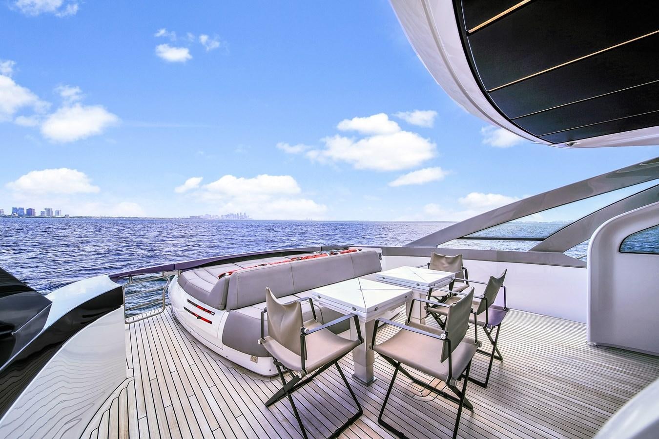 a table and chairs on a deck overlooking a large body of water aboard SANS SOUCI VIII Yacht for Sale
