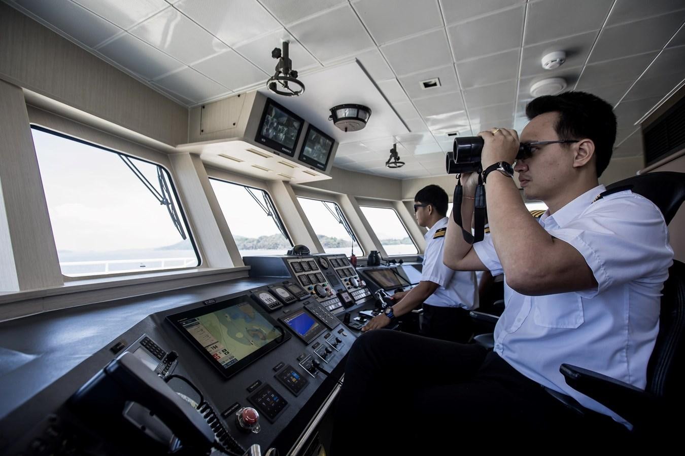 a man taking a picture of another man in a cockpit aboard VANORA Yacht for Sale