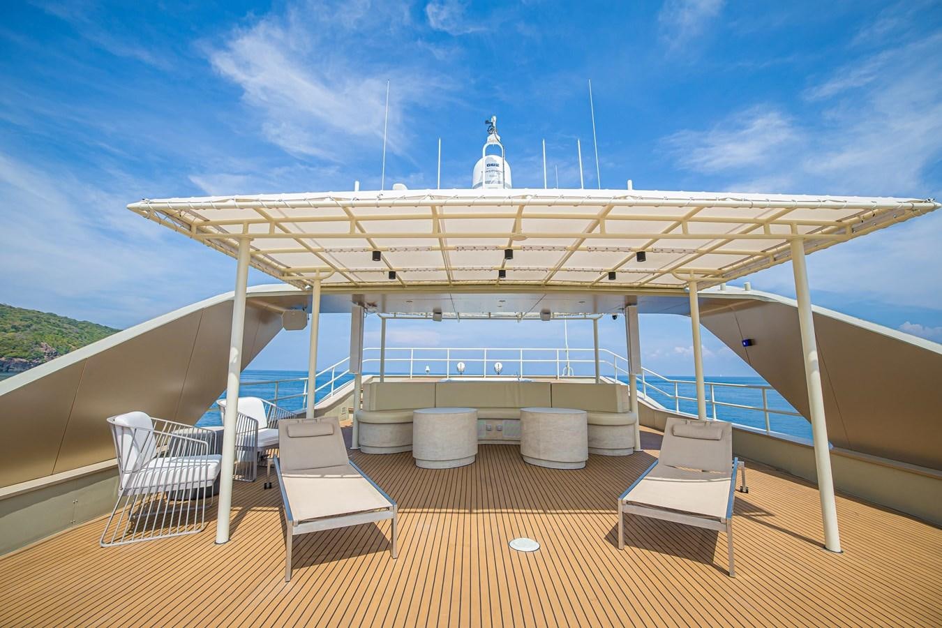 a deck with chairs and a table on it aboard VANORA Yacht for Sale