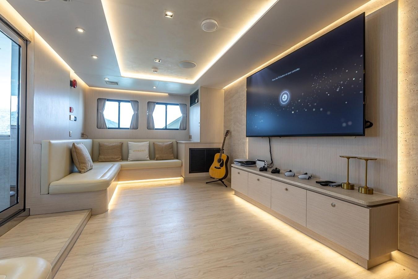 a room with a couch and a guitar aboard VANORA Yacht for Sale