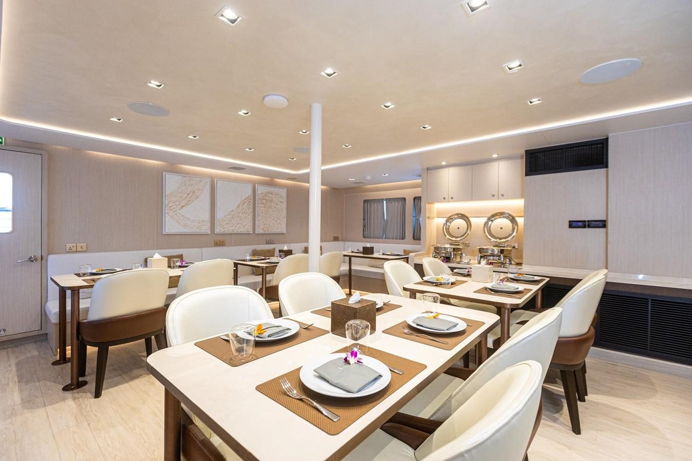 a large room with tables and chairs aboard VANORA Yacht for Sale