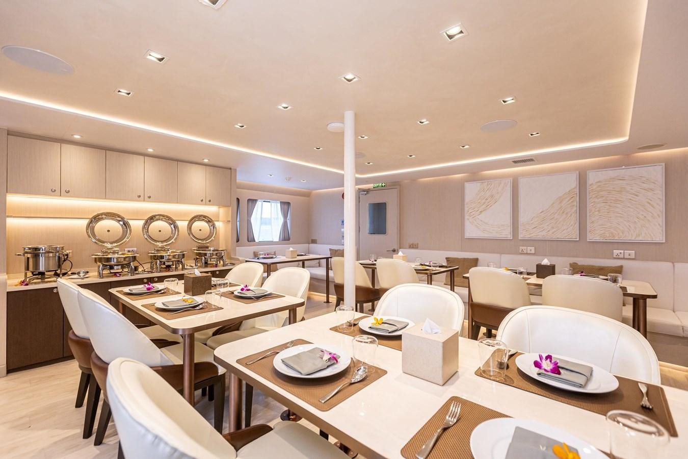a kitchen with a table and chairs aboard VANORA Yacht for Sale