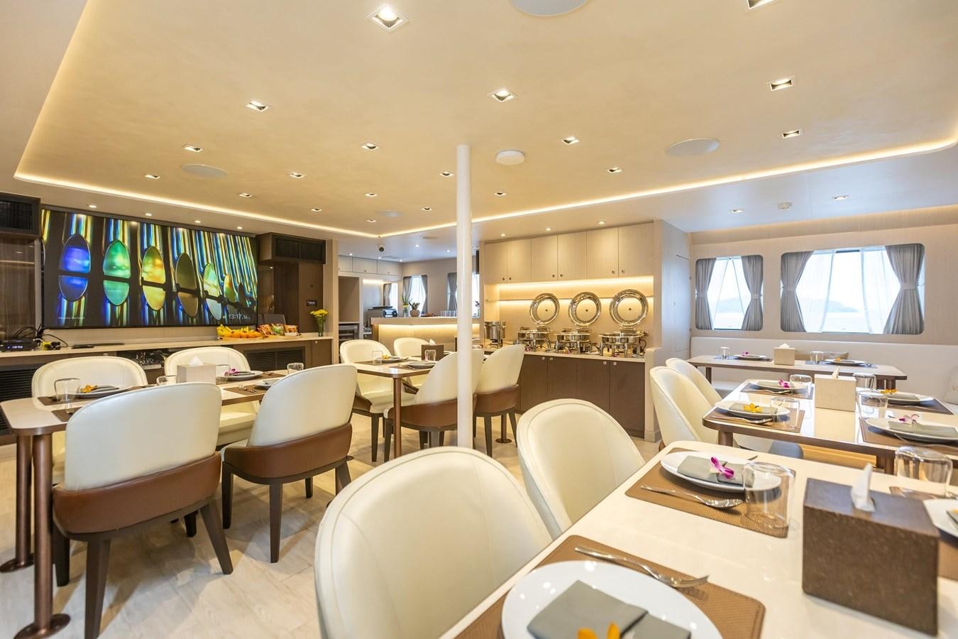 a room with tables and chairs aboard VANORA Yacht for Sale